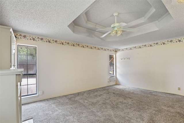 carpeted spare room with a textured ceiling, ornamental molding, and a raised ceiling