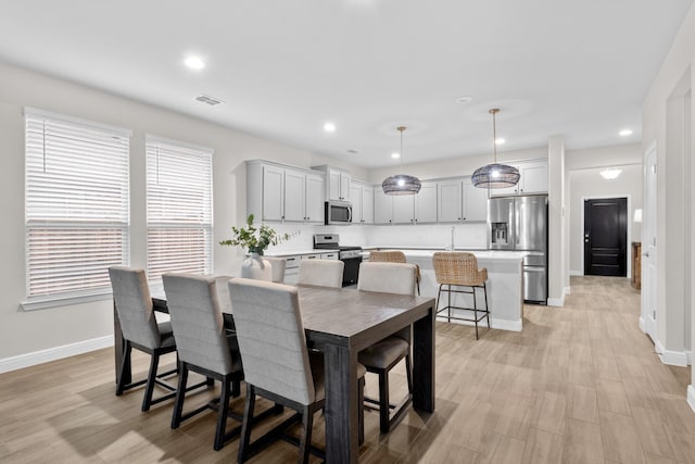 dining area with baseboards, visible vents, light wood-style flooring, and recessed lighting