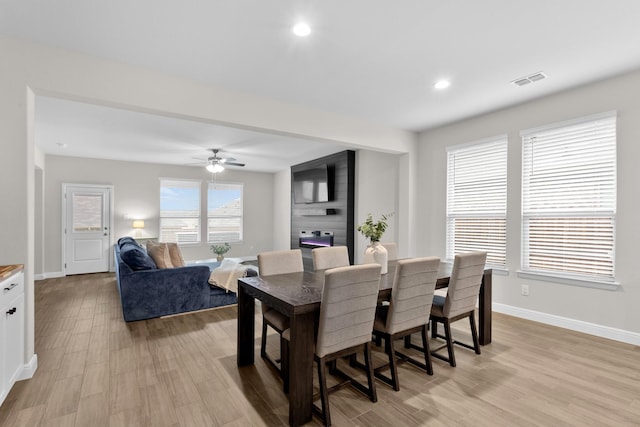 dining space featuring light wood-type flooring, visible vents, and baseboards