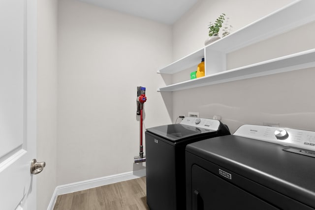 washroom with light wood-style floors, laundry area, baseboards, and separate washer and dryer