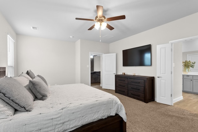 bedroom with visible vents, a ceiling fan, and light colored carpet