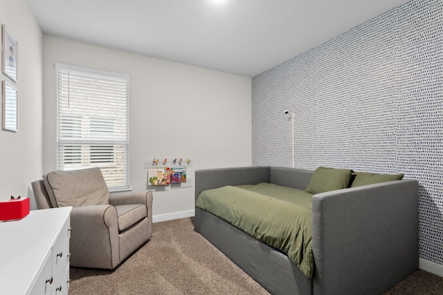 bedroom featuring carpet floors, an accent wall, and baseboards