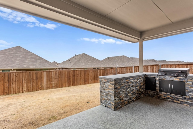 view of patio featuring exterior kitchen, a fenced backyard, and area for grilling