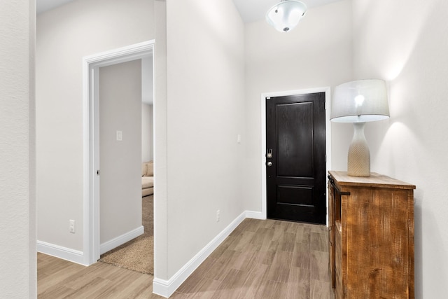 foyer featuring baseboards and light wood finished floors