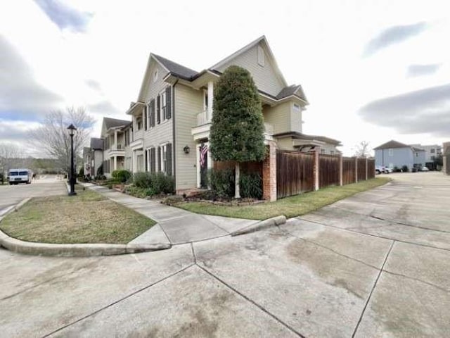 view of home's exterior with a residential view and fence