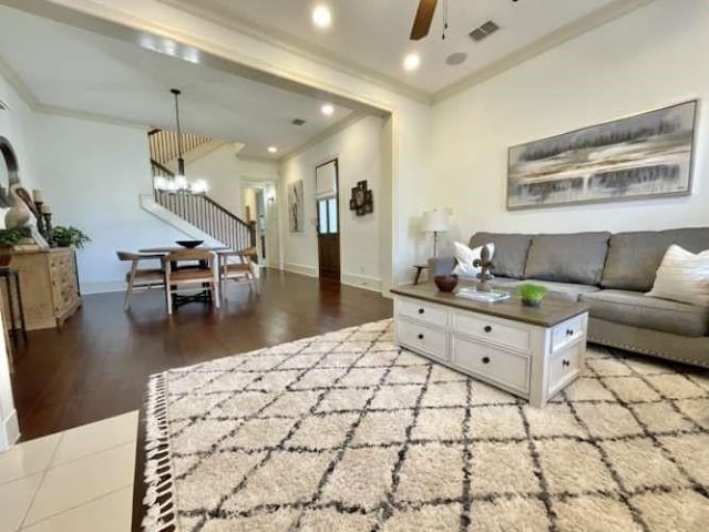 living room with crown molding, recessed lighting, a ceiling fan, baseboards, and stairs