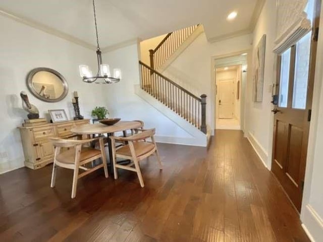 dining area with a notable chandelier, dark wood-style flooring, baseboards, stairs, and ornamental molding