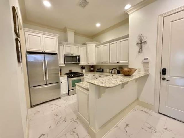 kitchen featuring marble finish floor, stainless steel appliances, visible vents, ornamental molding, and a peninsula