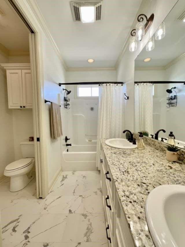 bathroom featuring crown molding, marble finish floor, visible vents, and a sink