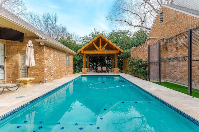 outdoor pool featuring a patio area, fence, and a gazebo