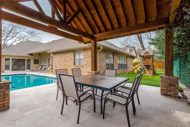 view of patio with a fenced in pool, outdoor dining area, a playground, and fence