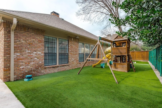 view of play area with a fenced backyard and a yard