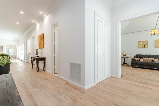 hall with light wood-style flooring, recessed lighting, visible vents, and crown molding