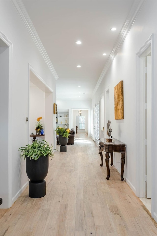 corridor with ornamental molding, recessed lighting, light wood-style flooring, and baseboards