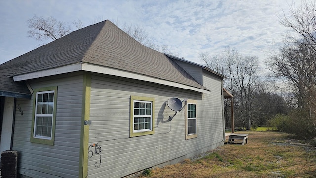 view of side of property with a shingled roof