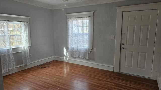 interior space with a healthy amount of sunlight, crown molding, wood finished floors, and a textured wall