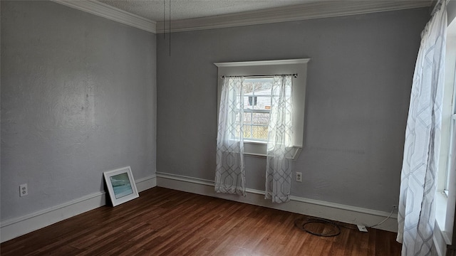 spare room with a textured ceiling, a textured wall, dark wood-style flooring, baseboards, and crown molding