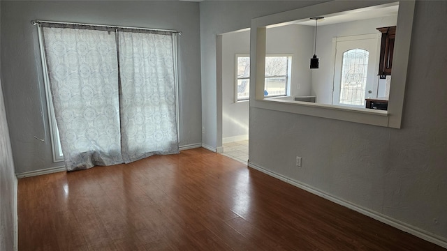 empty room with baseboards and wood finished floors