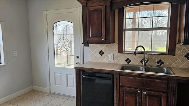 kitchen with black dishwasher, light tile patterned floors, backsplash, and a sink