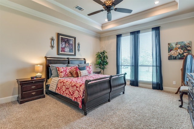 bedroom featuring a tray ceiling, carpet flooring, visible vents, and crown molding