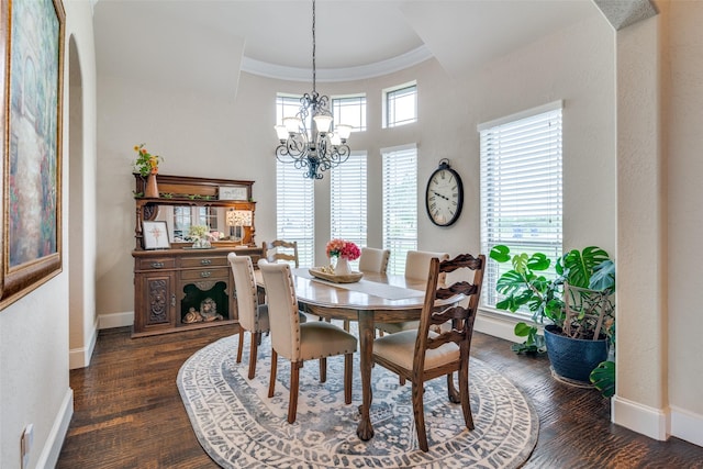 dining space featuring an inviting chandelier, crown molding, baseboards, and dark wood-style flooring