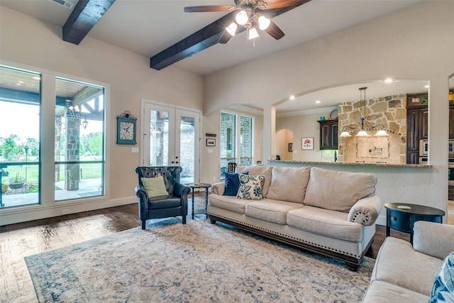 living area with baseboards, ceiling fan, beamed ceiling, wood finished floors, and french doors