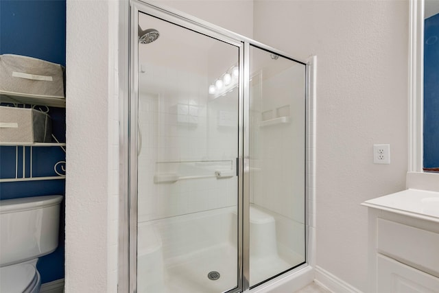 full bath featuring vanity, a shower stall, and toilet