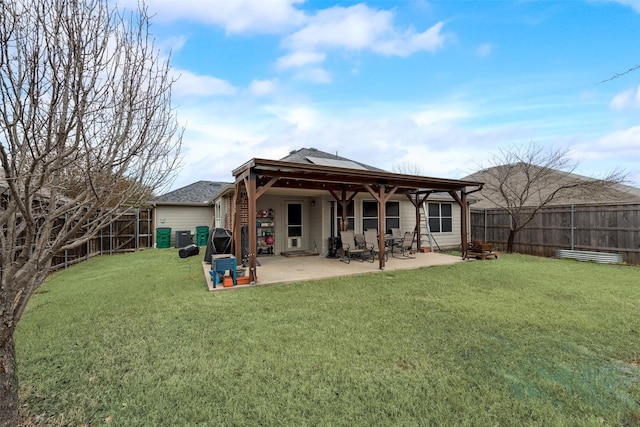 rear view of house with a fenced backyard, roof with shingles, a lawn, and a patio