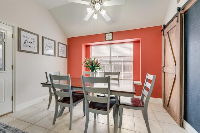 dining room featuring a ceiling fan, vaulted ceiling, baseboards, and a barn door