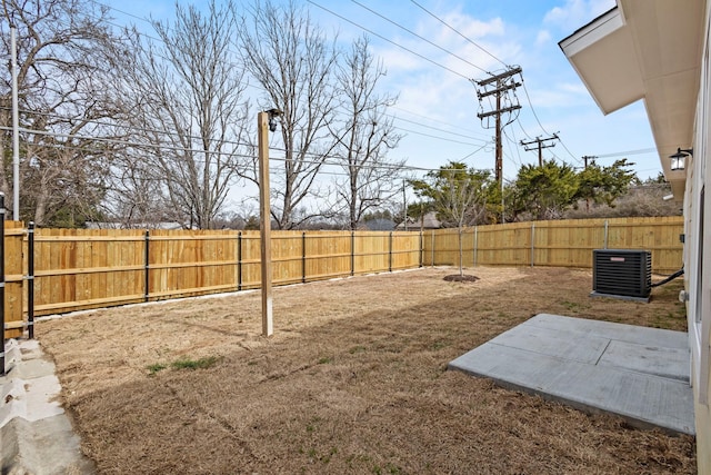 view of yard with central AC unit, a patio area, and a fenced backyard