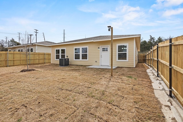 rear view of house featuring a patio, central AC unit, and a fenced backyard