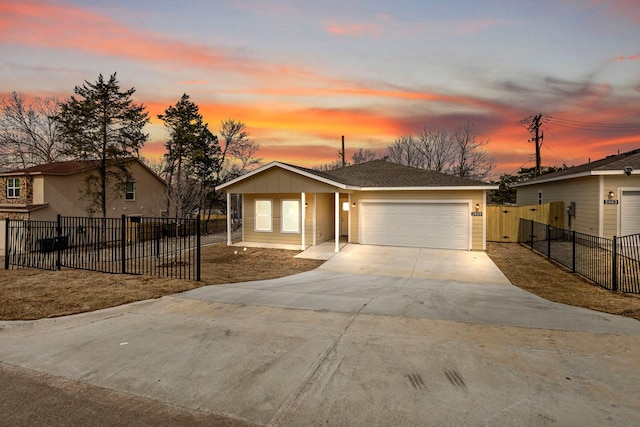 view of front of house featuring a garage, driveway, fence, and a gate