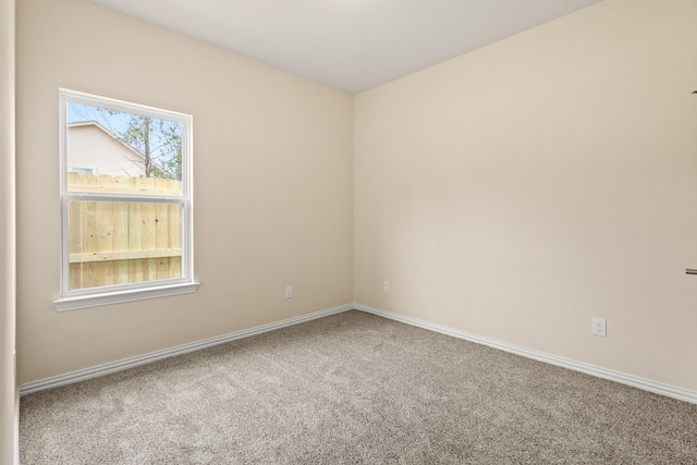 carpeted empty room with baseboards