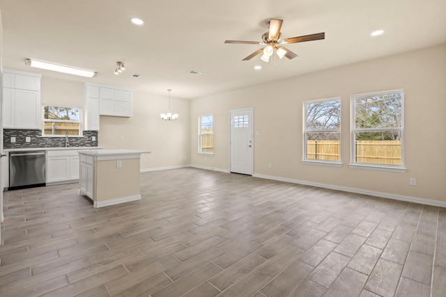 kitchen featuring decorative backsplash, light wood-style floors, open floor plan, a kitchen island, and dishwasher