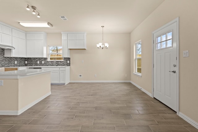 kitchen with tasteful backsplash, plenty of natural light, visible vents, and a sink