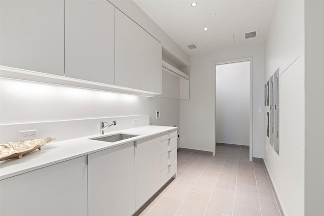 kitchen featuring recessed lighting, light countertops, visible vents, a sink, and baseboards