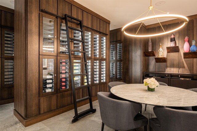 wine room featuring wood walls and a chandelier