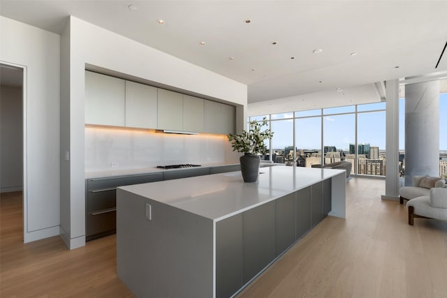 kitchen featuring light wood-type flooring, open floor plan, floor to ceiling windows, and modern cabinets