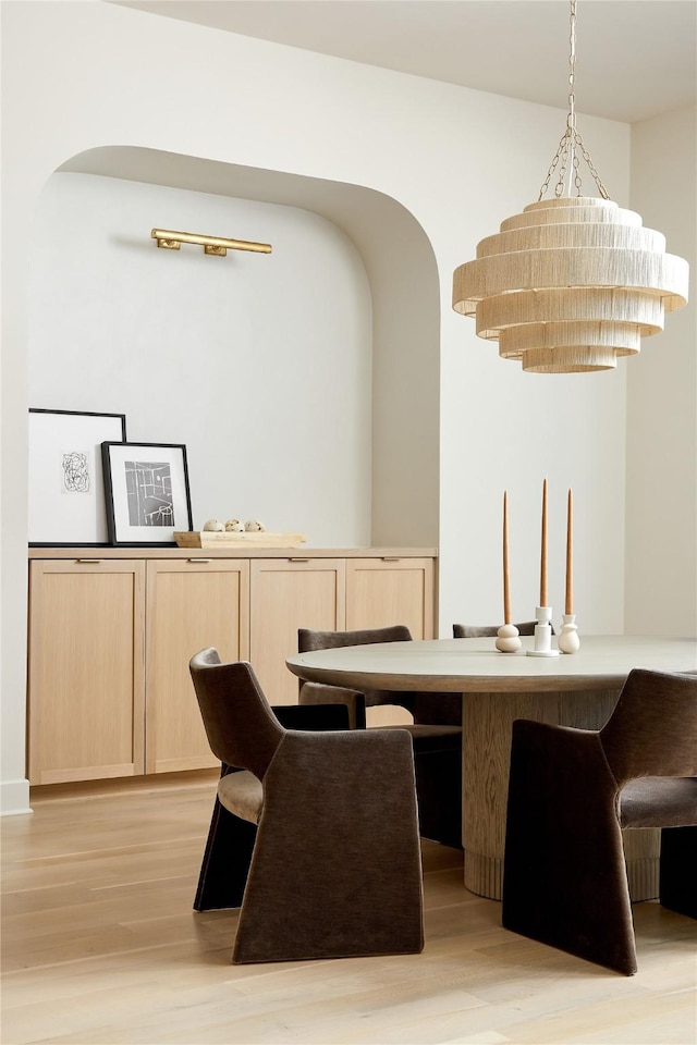 bar featuring light wood-style flooring and decorative light fixtures