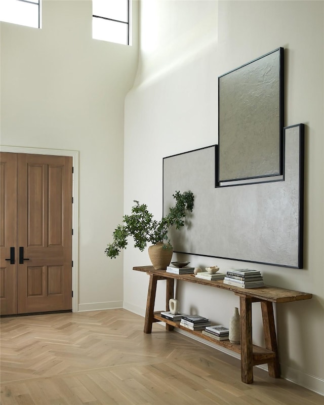 foyer entrance featuring a high ceiling and baseboards