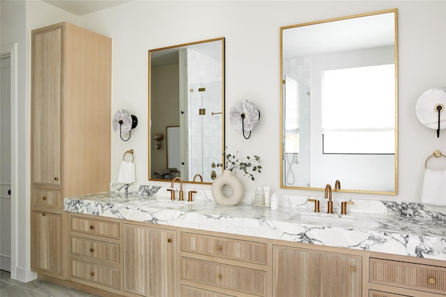 bathroom featuring a sink, a tile shower, and double vanity