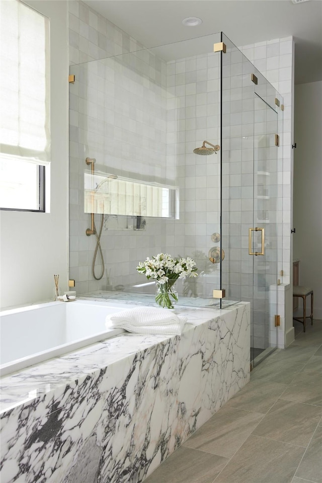 bathroom with a stall shower and a garden tub