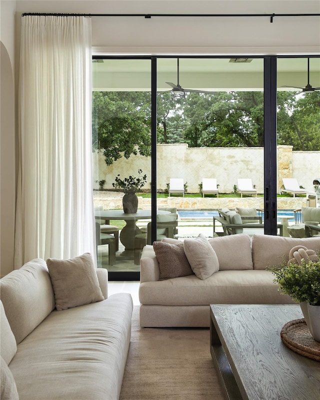 living area featuring ceiling fan and arched walkways