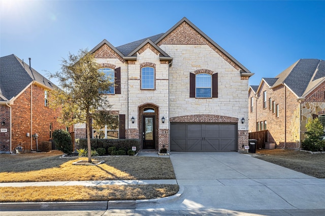 french provincial home with brick siding, driveway, and an attached garage