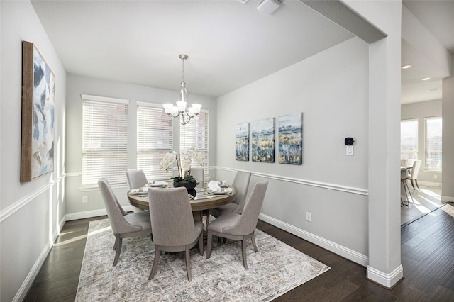 dining room with visible vents, dark wood finished floors, baseboards, and an inviting chandelier