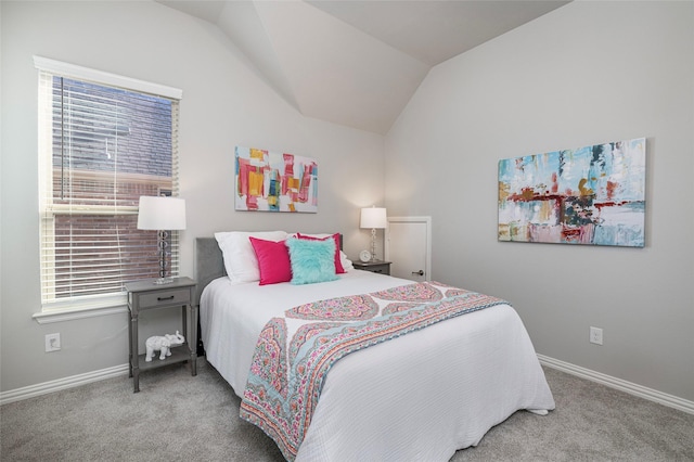 carpeted bedroom featuring baseboards and vaulted ceiling