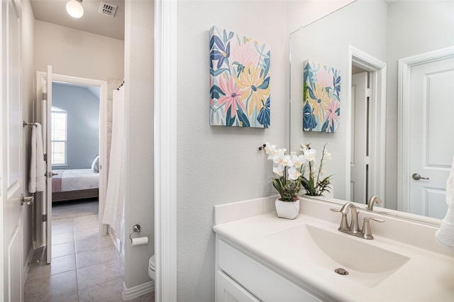 bathroom featuring toilet, vanity, visible vents, and tile patterned floors