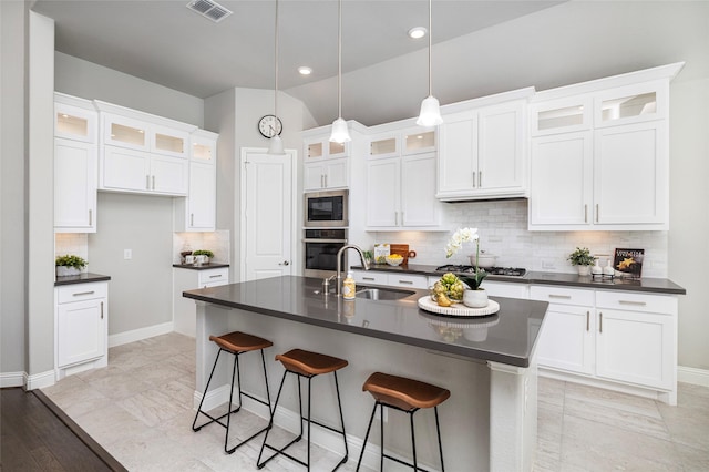 kitchen with a sink, visible vents, white cabinetry, appliances with stainless steel finishes, and dark countertops