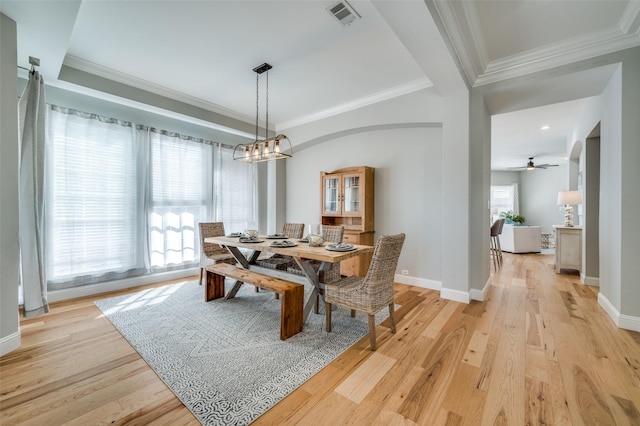 dining room featuring crown molding, visible vents, baseboards, light wood-type flooring, and an inviting chandelier