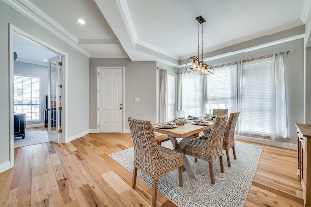 dining area with light wood-style flooring, baseboards, and crown molding